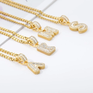 Detail of Cuban link necklaces with iced out gold plated alphabet pendants A K M S