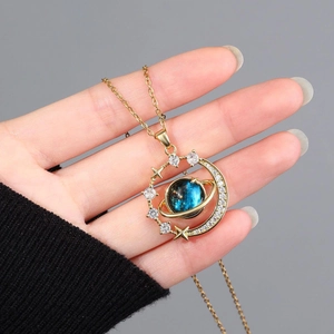 Detail of gold planet necklace with blue nebula stone and crescent moon accents