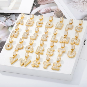 Detail of 26 gold-plated letter pendants with micro-pave cubic zirconia on white display