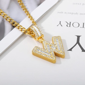Detailed view of capital letter W pendant with micro-paved zircons on gold Cuban chain