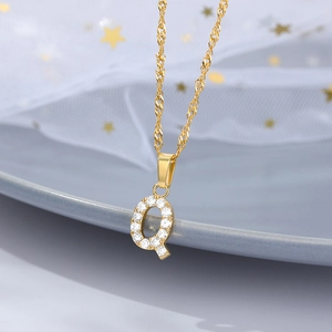 Dettaglio della collana con ciondolo a lettera Q dorata e zirconi scintillanti