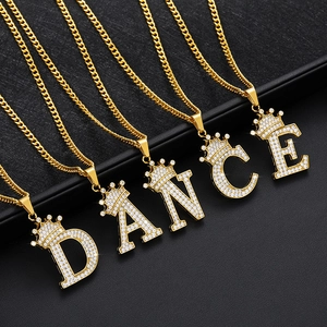 Makroaufnahme goldener Kronen-Buchstabenanhänger mit eisigen Strasssteinen und Steinen