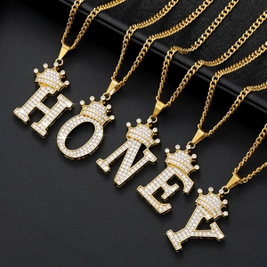 Nahaufnahme goldener Kronen-Buchstabenanhänger HONEY mit funkelnden Zirkonia-Steinen