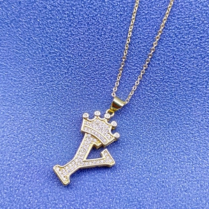 Gros plan détaillé du pendentif couronne lettre Y en or 18k avec zircons brillants