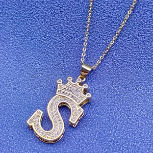 Vue macro du pendentif lettre S plaqué or 18k avec couronne et pavé de diamants