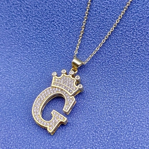 Détail du pendentif couronne lettre G en or 18k serti de cristaux étincelants