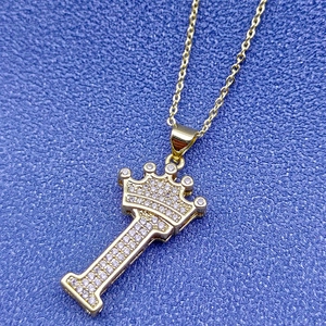 Macro d'un pendentif lettre I plaqué or 18k avec couronne et zircons scintillants