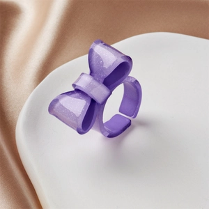 Detail eines lila Harz-Schleifenrings mit Glitzerdekor und verstellbarem Band
