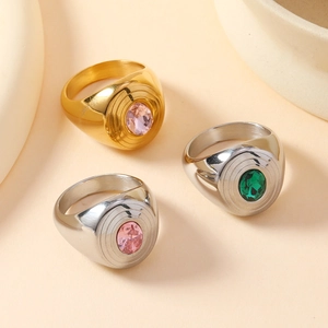 Detailed macro view of gold and silver signet rings with oval pink and green gemstones