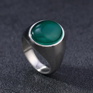 Macro shot of an oval green opal gemstone set in a wide polished stainless steel ring band