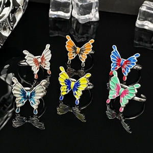 Detailed view of colorful liquid butterfly rings with enamel finish on black background