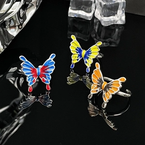 Macro shot of liquid butterfly rings in three gradient colors on reflective black surface