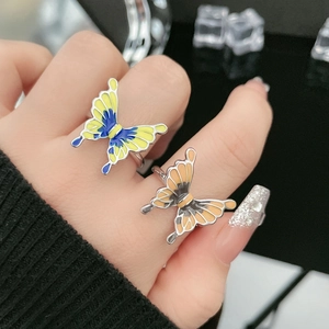 Detail view of colorful liquid butterfly rings with gradient enamel on silver metal bands