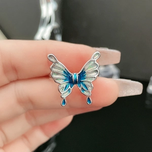 Detailed macro of a silver butterfly ring with blue gradient enamel and glitter finish