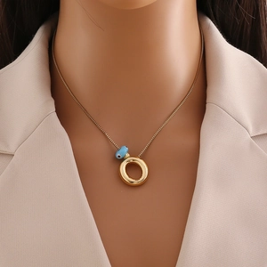 Détail d'un pendentif œil maléfique en or 18 carats sur une chaîne à mailles carrées