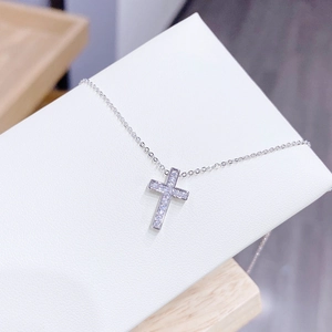 Close-up of cross pendant necklace with micro-pave white zircon on silver-plated chain