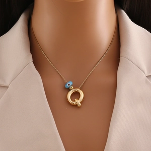 Détail du collier en or 18 carats avec pendentif lettre Q et perle œil bleu sur mannequin