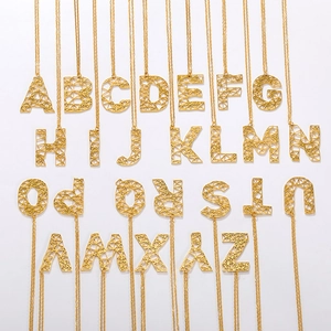 Detail van 26 holle goudkleurige hoofdletterhangers met fijne schakelkettingen