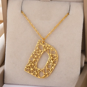 Detailweergave van een gouden holle geometrische letter D-hanger aan een klassieke ketting