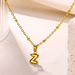 Detailed macro of a 18K gold plated Z letter pendant on a beaded necklace chain
