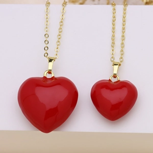 Détail des pendentifs cœur en émail rouge sur de fines chaînes dorées à l'or fin