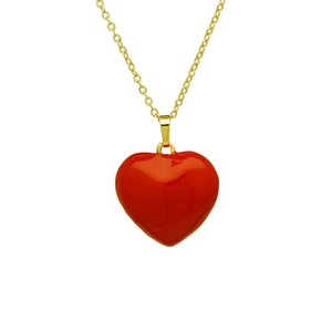 Gros plan d'un pendentif cœur rouge brillant avec une chaîne plaquée or polie sur fond blanc