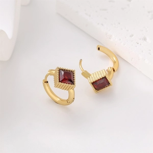 Detailed macro view of 18k gold-plated square red gemstone hoop earrings on a stone base