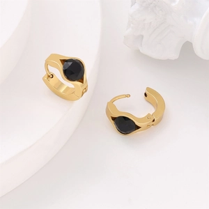 Golden stainless steel hoop earrings with round faceted black gemstone on white stand