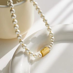Minimalist 18k gold plated pearl necklace featuring a central gold rectangular bar charm
