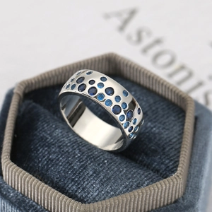 Macro shot of a silver vintage band ring with blue stones in a hexagonal jewelry box