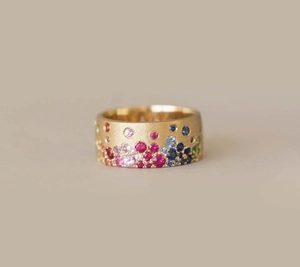 Close-up of matte gold ring featuring colorful zircon stones and brushed texture