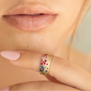 French retro gold ring with colorful gemstones and matte finish on model's hand