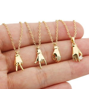 Lot de quatre colliers dorés avec pendentifs gestes de la main style rock et peace
