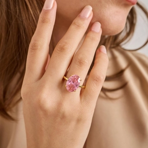 Elegant pink oval topaz ring with gold-plated four-prong setting worn by a model