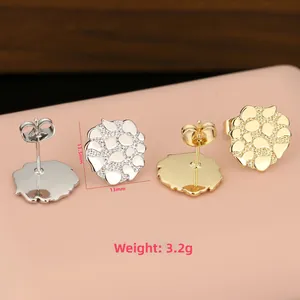 Detailansicht zu Größe und Gewicht der blumenförmigen Metallohrstecker in Gold und Silber