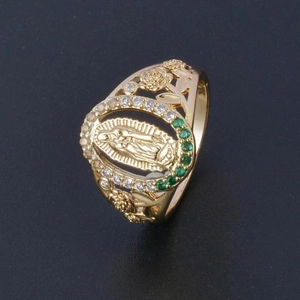 Bague dorée de la Vierge Marie avec cristaux verts et détails de rose sur fond noir
