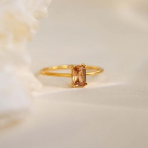 Elegant gold ring featuring a rectangular champagne zircon in a minimalist claw setting
