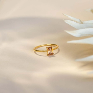 Close-up of champagne rectangle zircon ring with four-prong setting and gold band