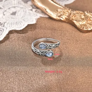 Dettaglio anello cucchiaio vintage con pietre blu a goccia e incisioni a rilievo