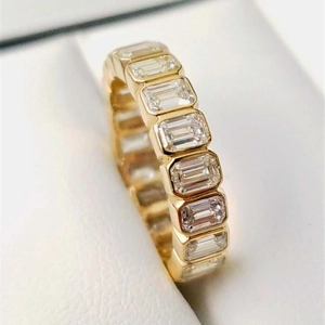 Elegant gold eternity ring featuring emerald-cut cubic zirconia in a square setting