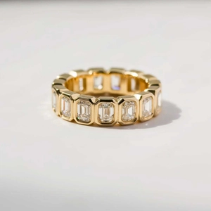 Detail view of gold eternity band with emerald cut cubic zirconia in bezel setting
