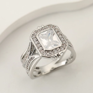 Elegant square moissanite ring with a halo setting and split shank on a beige pedestal