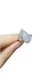 Detailed view of teardrop opal ring with asymmetric crown setting and silver finish