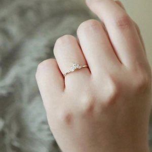 Detailansicht eines goldfarbenen Kronenrings mit Marquise-Steinen an der Hand
