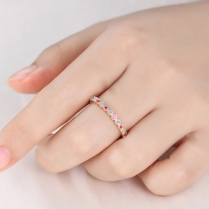 Elegante anello dorato con cristalli rosa e bianchi alternati indossato sulla mano