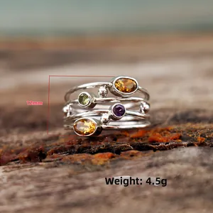Dettaglio di un anello bohémien in argento con gemme multicolori e altezza di 12 mm
