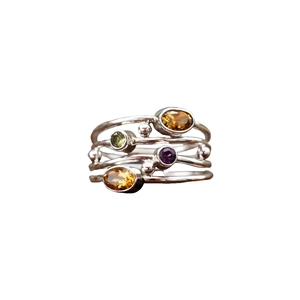 Anello multistrato in argento stile boho con quattro gemme ovali colorate su fondo bianco