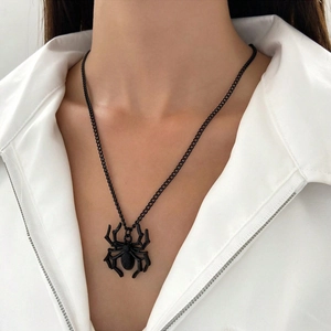 Close-up of black 3D spider pendant necklace with fine O-chain on white collar shirt