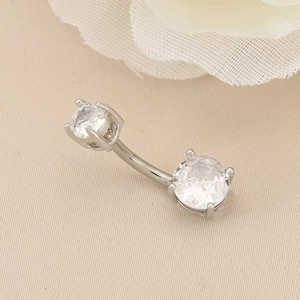 Macro shot of double-headed crystal navel ring with silver curved barbell and claw settings