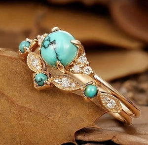 Macro detail of Bohemian ring featuring turquoise stone and gold leaf-shaped metalwork